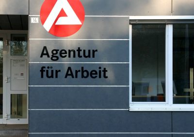 Fräsbuchstaben und rundes Schild an der Fassase